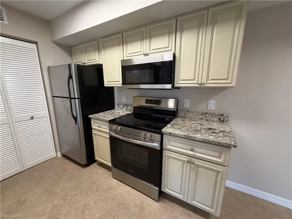a kitchen with stainless steel appliances granite countertop a stove a refrigerator and a microwave