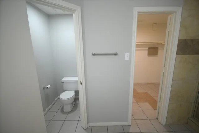 a bathroom with a granite countertop toilet and a sink