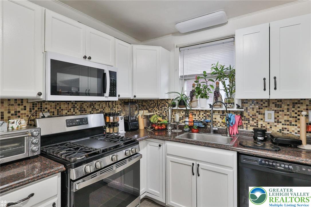 1147 Arcadia Street Bethlehem, PA 18018 - Photo 23 of 66 a kitchen with stainless steel appliances kitchen island granite countertop a sink a stove and a microwave