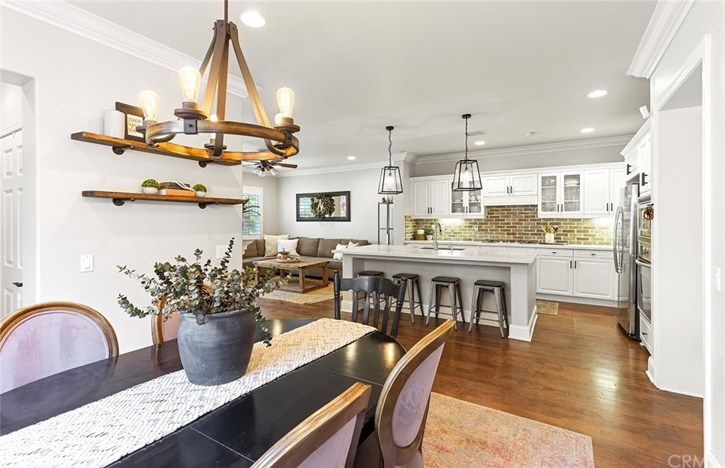 6 Pomegranate Street Ladera Ranch, CA 92694 - Photo 6 of 40 a kitchen with stainless steel appliances a dining table chairs stove and refrigerator