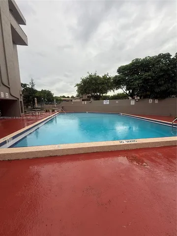 a view of swimming pool with outdoor seating and yard in back