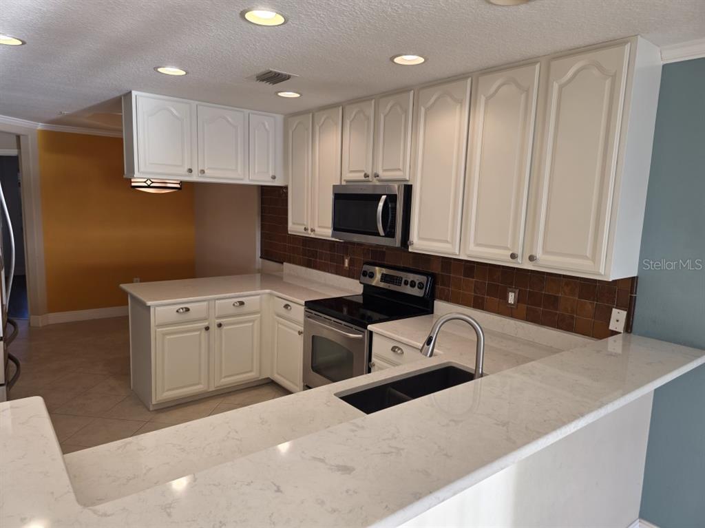7070 Key Haven Road, Unit 402 Seminole, FL 33777 - Photo 13 of 34 a kitchen with a sink a stove and refrigerator