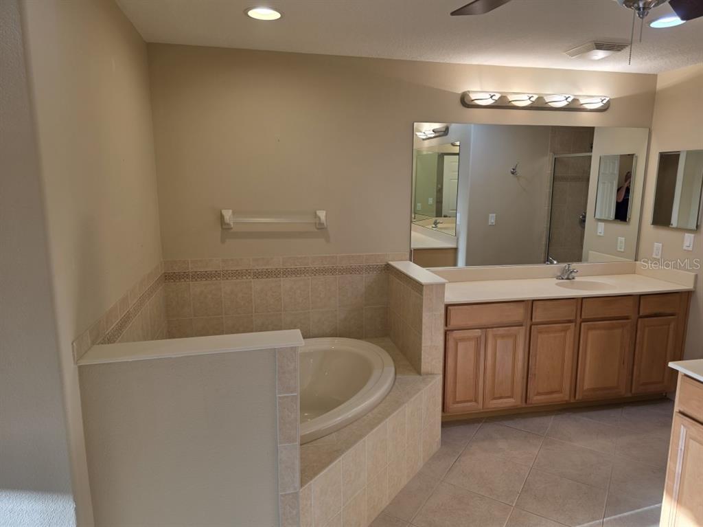 7070 Key Haven Road, Unit 402 Seminole, FL 33777 - Photo 20 of 34 a bathroom with a bathtub sink and a mirror