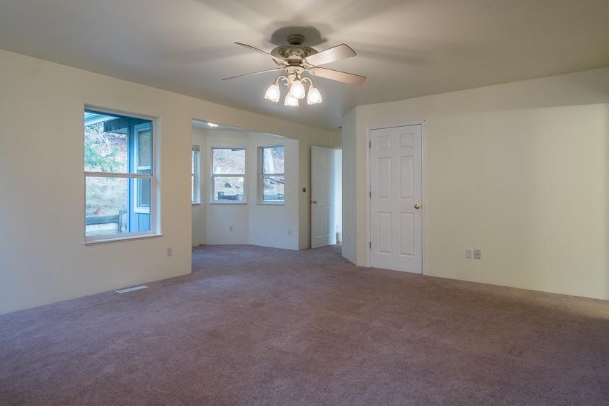 6550 Beagle Road White City, OR 97503 - Photo 7 of 24 an empty room with chandelier fan and windows