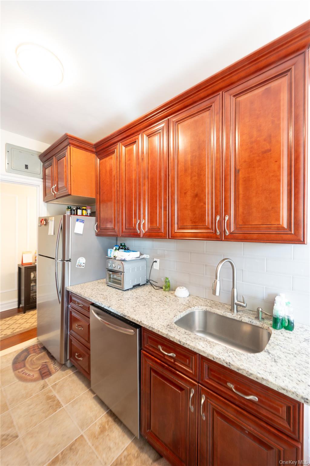 1468 Midland Avenue, Unit 4D Bronxville, NY 10708 - Photo 15 of 24 Kitchen with light stone counters, stainless steel appliances, backsplash, and light tile patterned floors