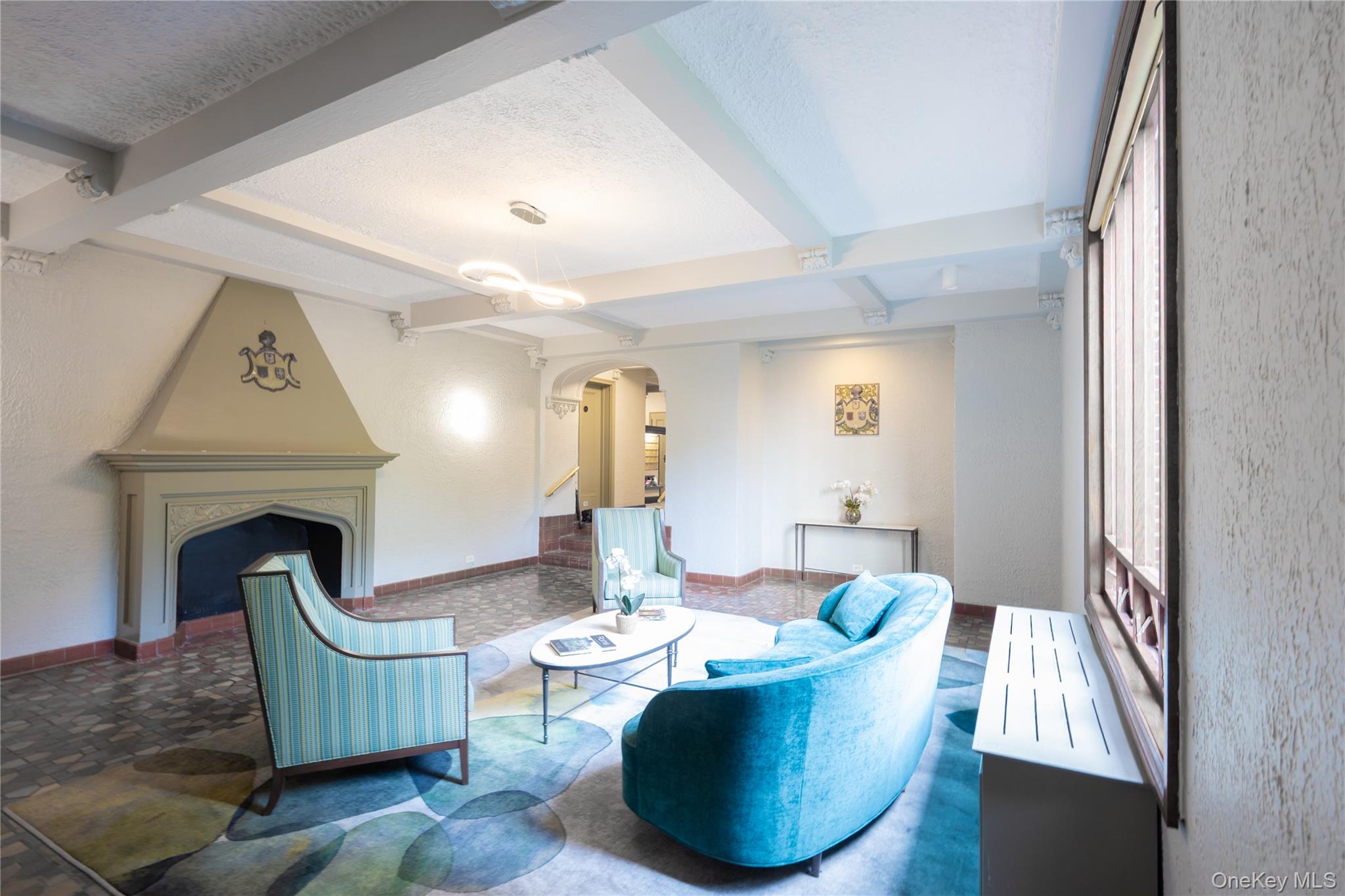 1468 Midland Avenue, Unit 4D Bronxville, NY 10708 - Photo 18 of 24 Living area featuring arched walkways, beam ceiling, a textured ceiling, a fireplace, and stairway