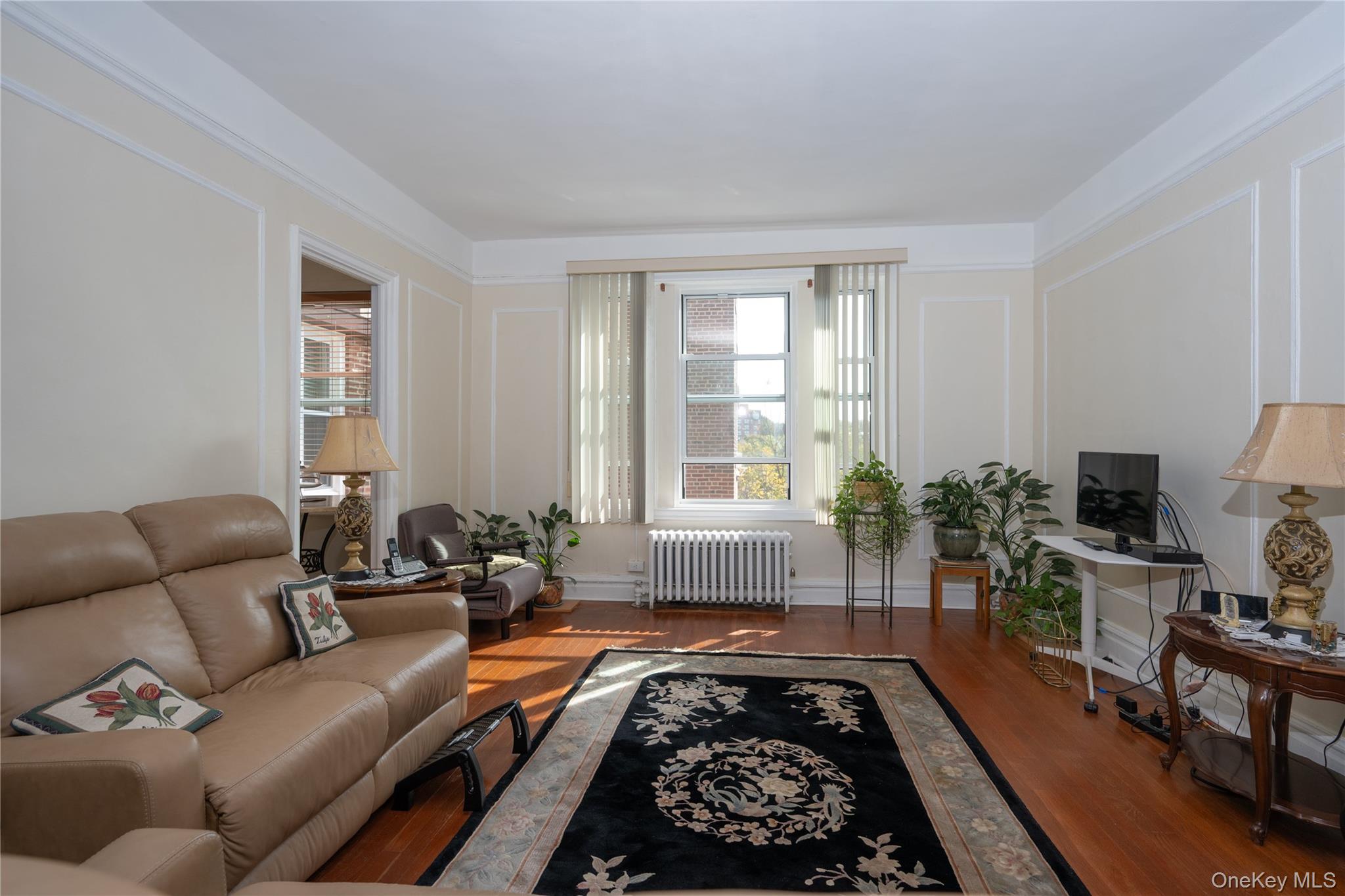 1468 Midland Avenue, Unit 4D Bronxville, NY 10708 - Photo 3 of 24 Living room featuring a decorative wall, wood finished floors, and radiator heating unit