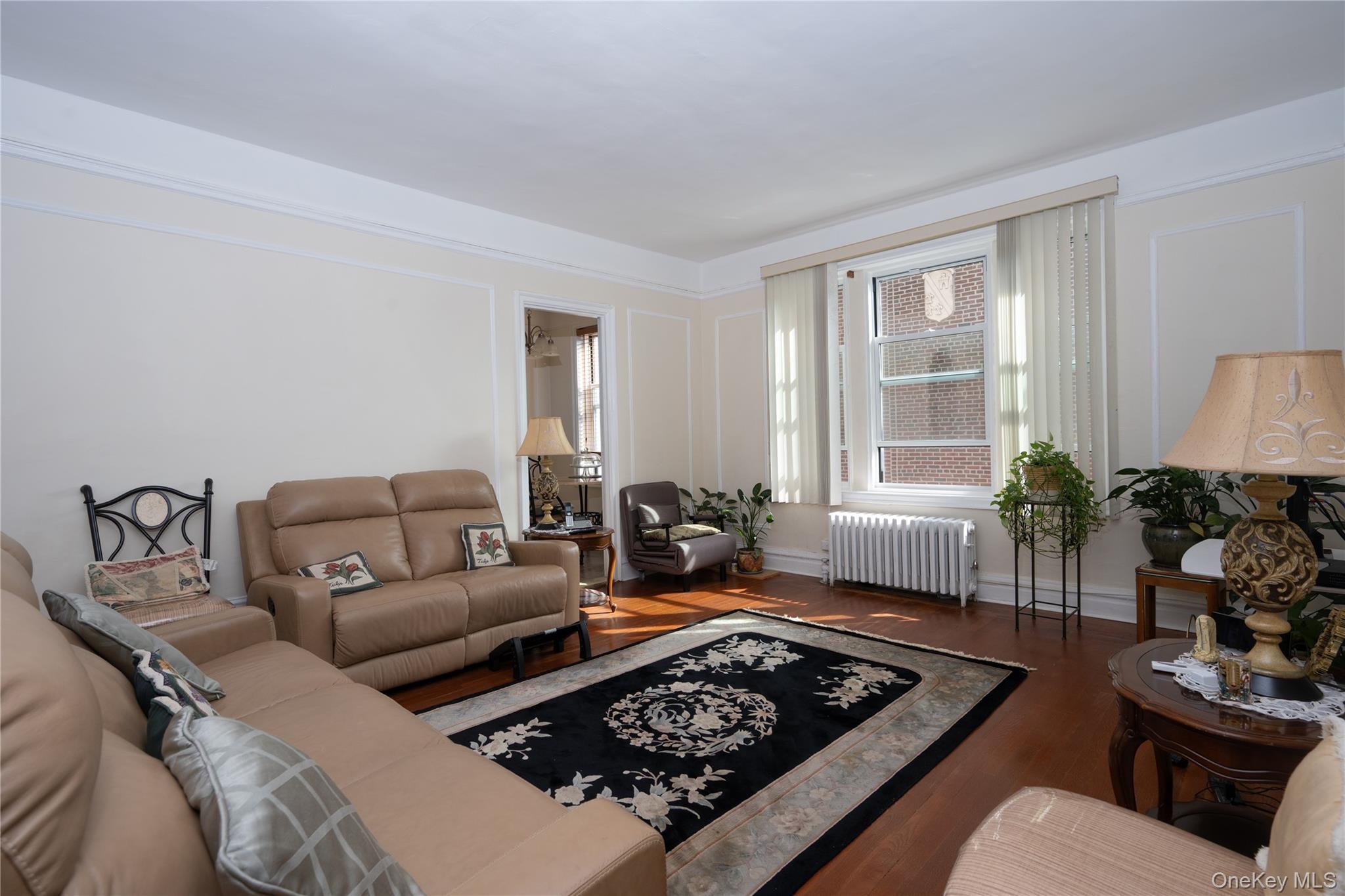 1468 Midland Avenue, Unit 4D Bronxville, NY 10708 - Photo 4 of 24 Living area with radiator, wood finished floors, and a decorative wall