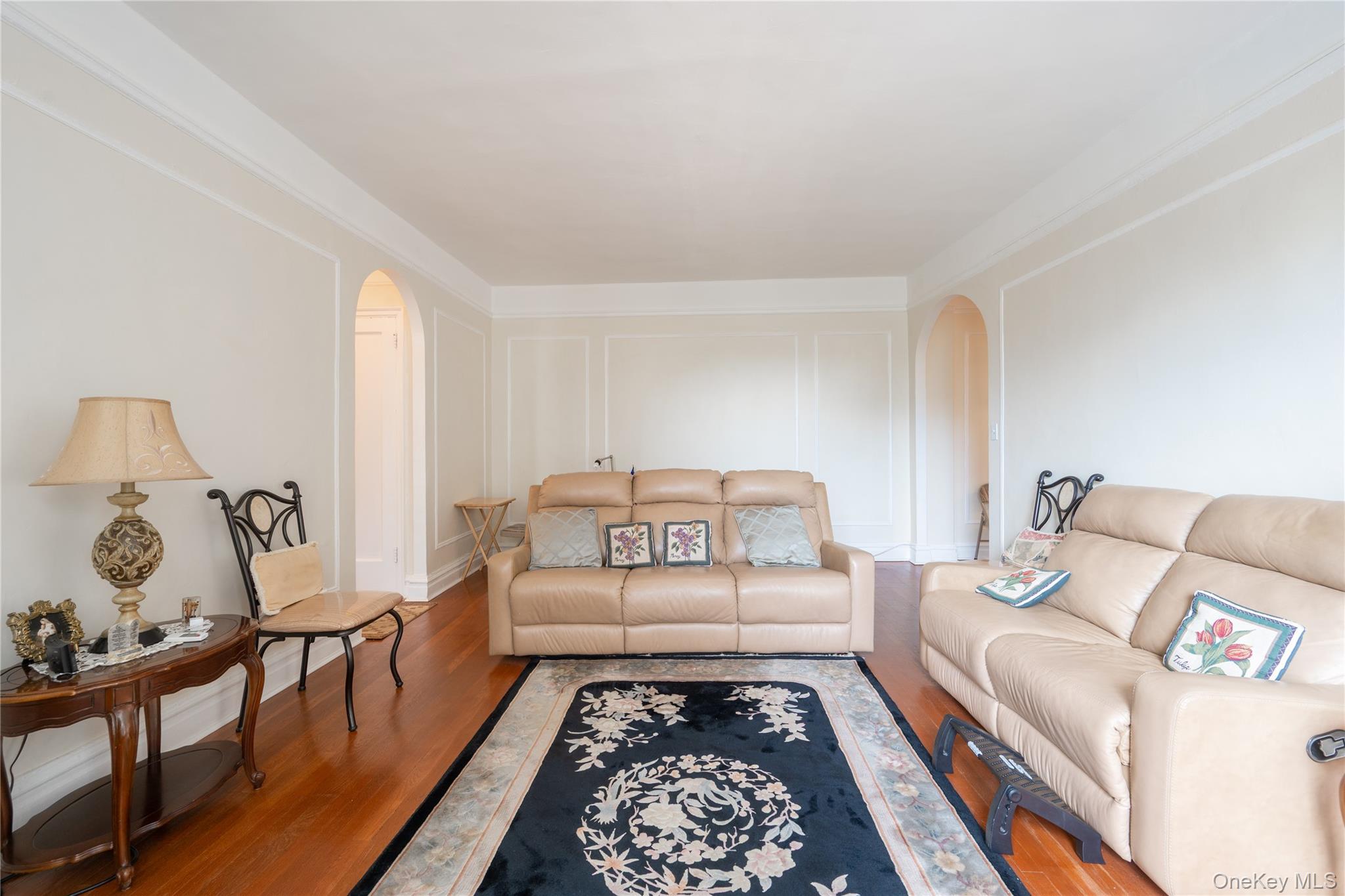 1468 Midland Avenue, Unit 4D Bronxville, NY 10708 - Photo 6 of 24 Living room with arched walkways, a decorative wall, and wood finished floors