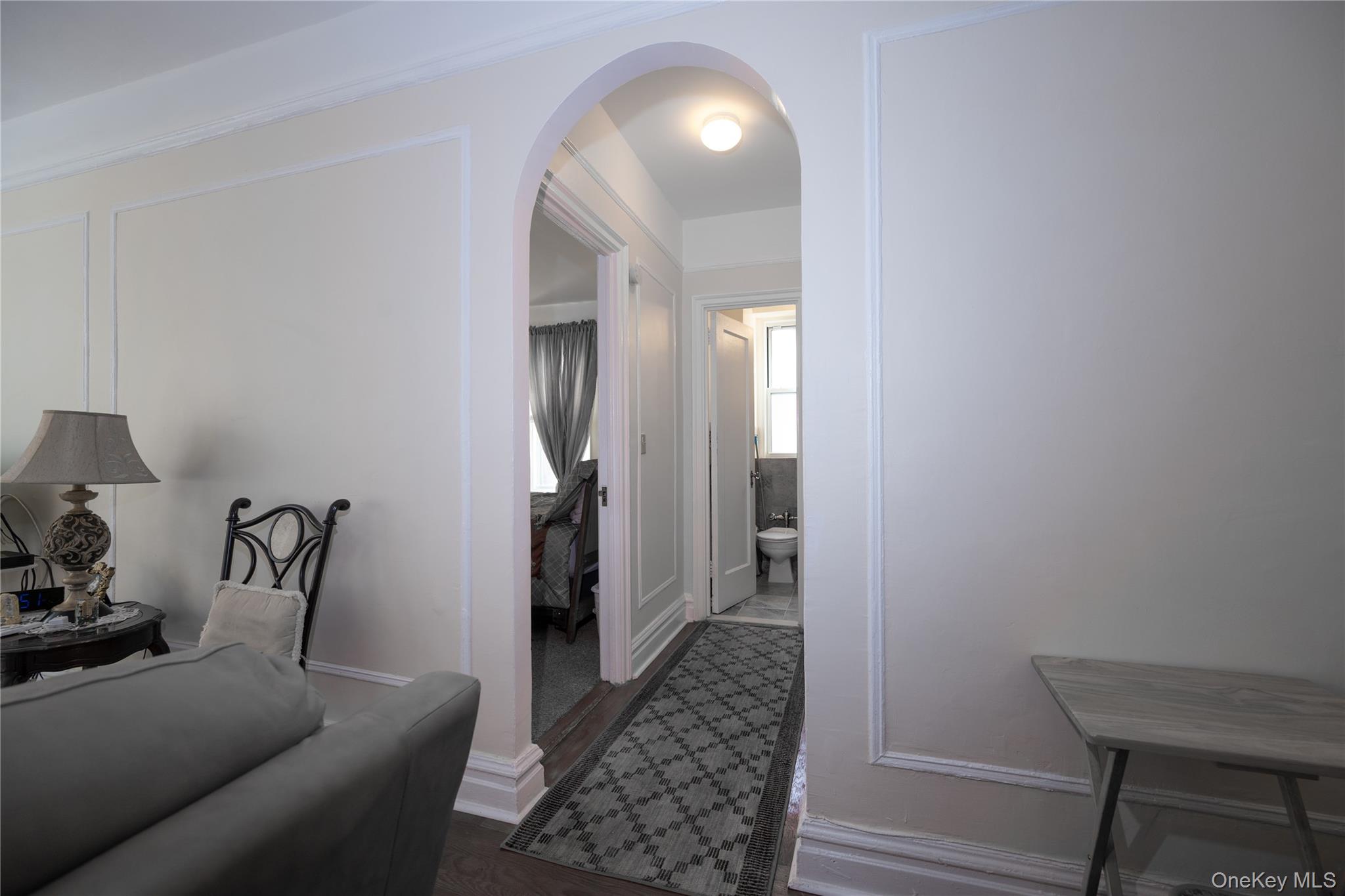 1468 Midland Avenue, Unit 4D Bronxville, NY 10708 - Photo 7 of 24 Corridor featuring arched walkways, dark wood-style flooring, and a decorative wall