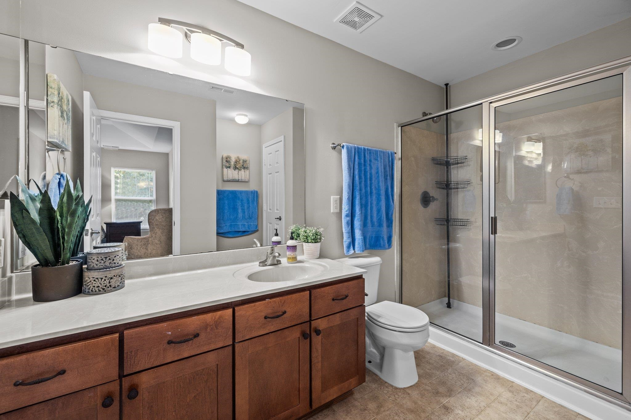 180 Solheim Lane Raleigh, NC 27603 - Photo 20 of 39 a bathroom with a granite countertop sink a toilet a mirror and shower