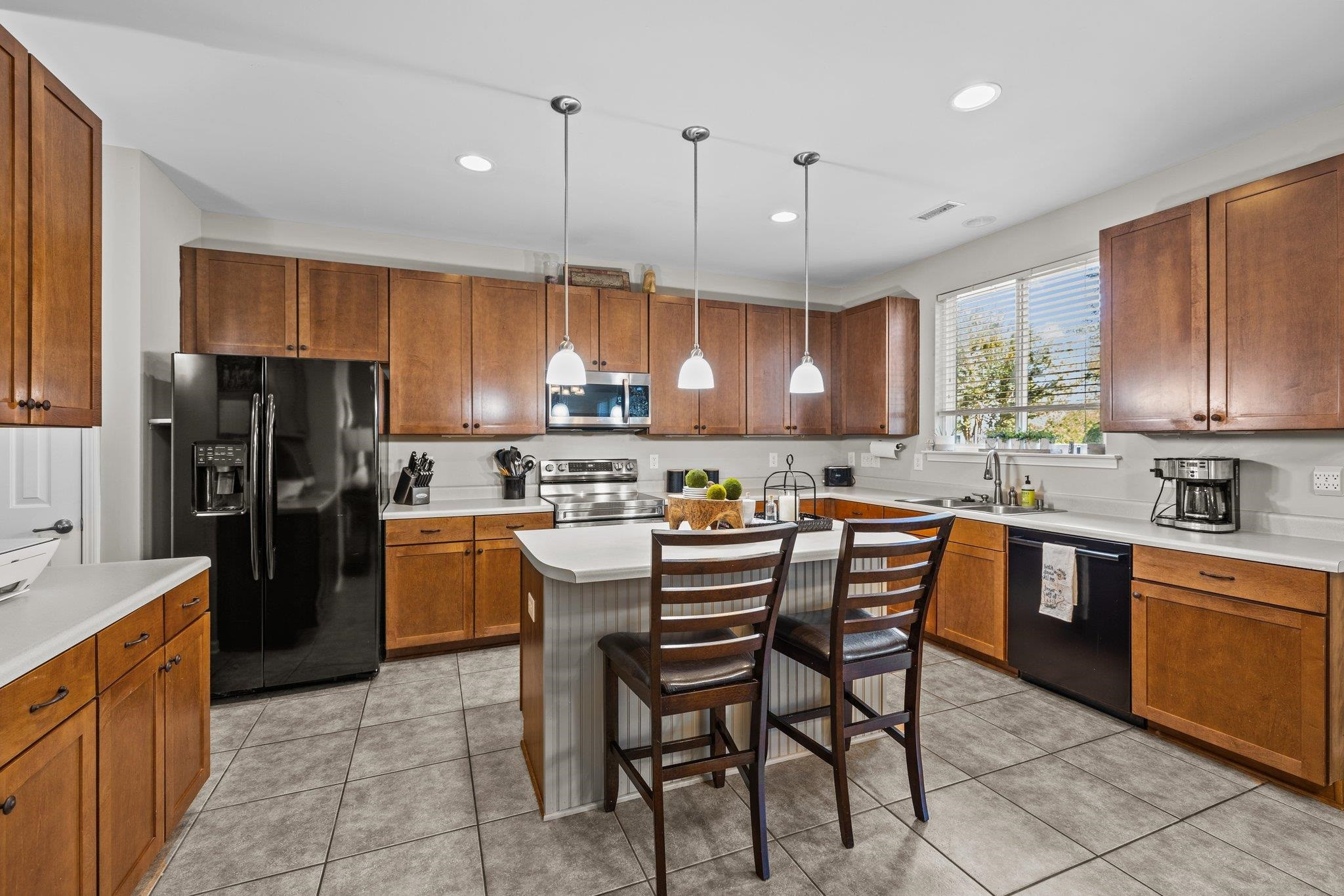 180 Solheim Lane Raleigh, NC 27603 - Photo 6 of 39 a kitchen with a refrigerator a sink a stove a dining table and chairs