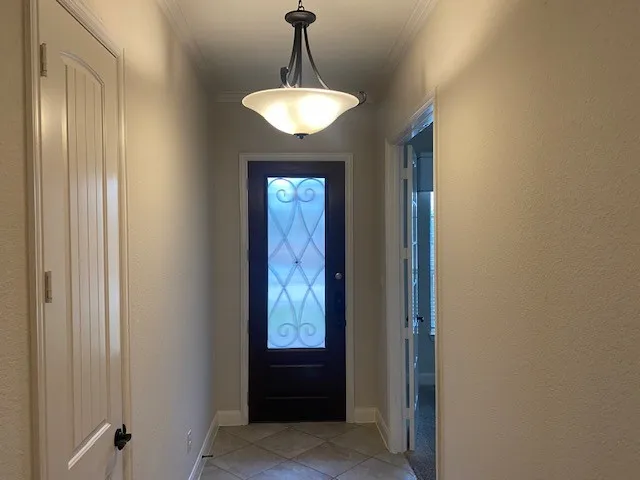 a view of a hallway with windows and chandelier