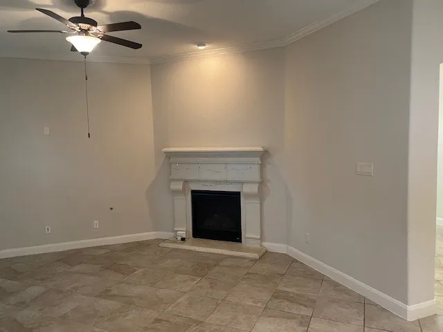 a view of empty room with fan and a fireplace