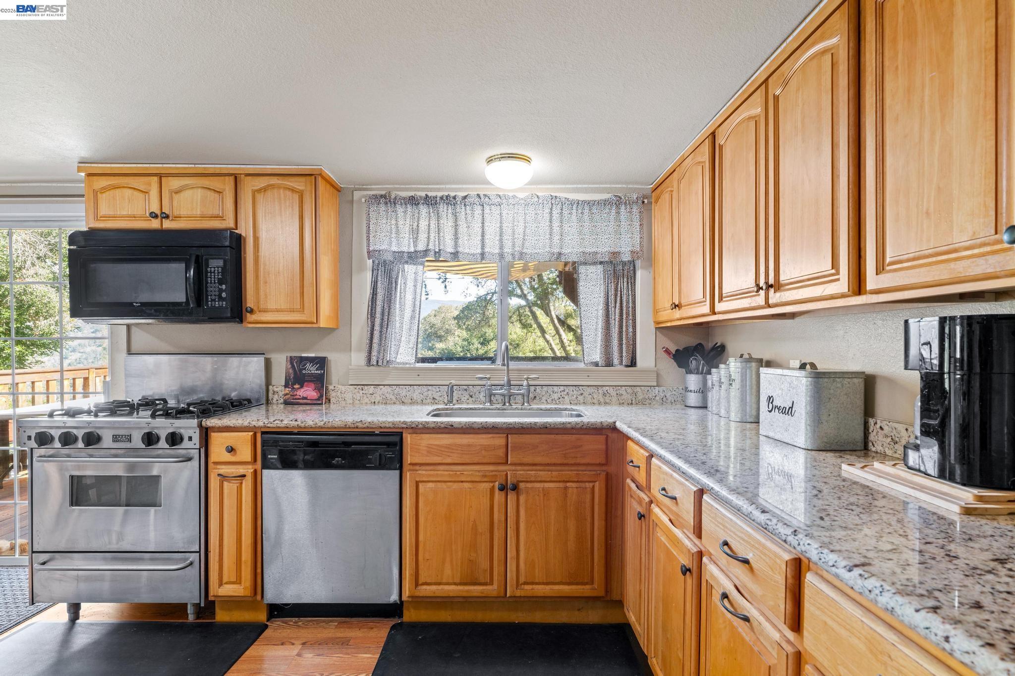 7777 Del Valle Road Livermore, CA 94550 - Photo 23 of 60 a kitchen with stainless steel appliances granite countertop a stove a sink and a microwave