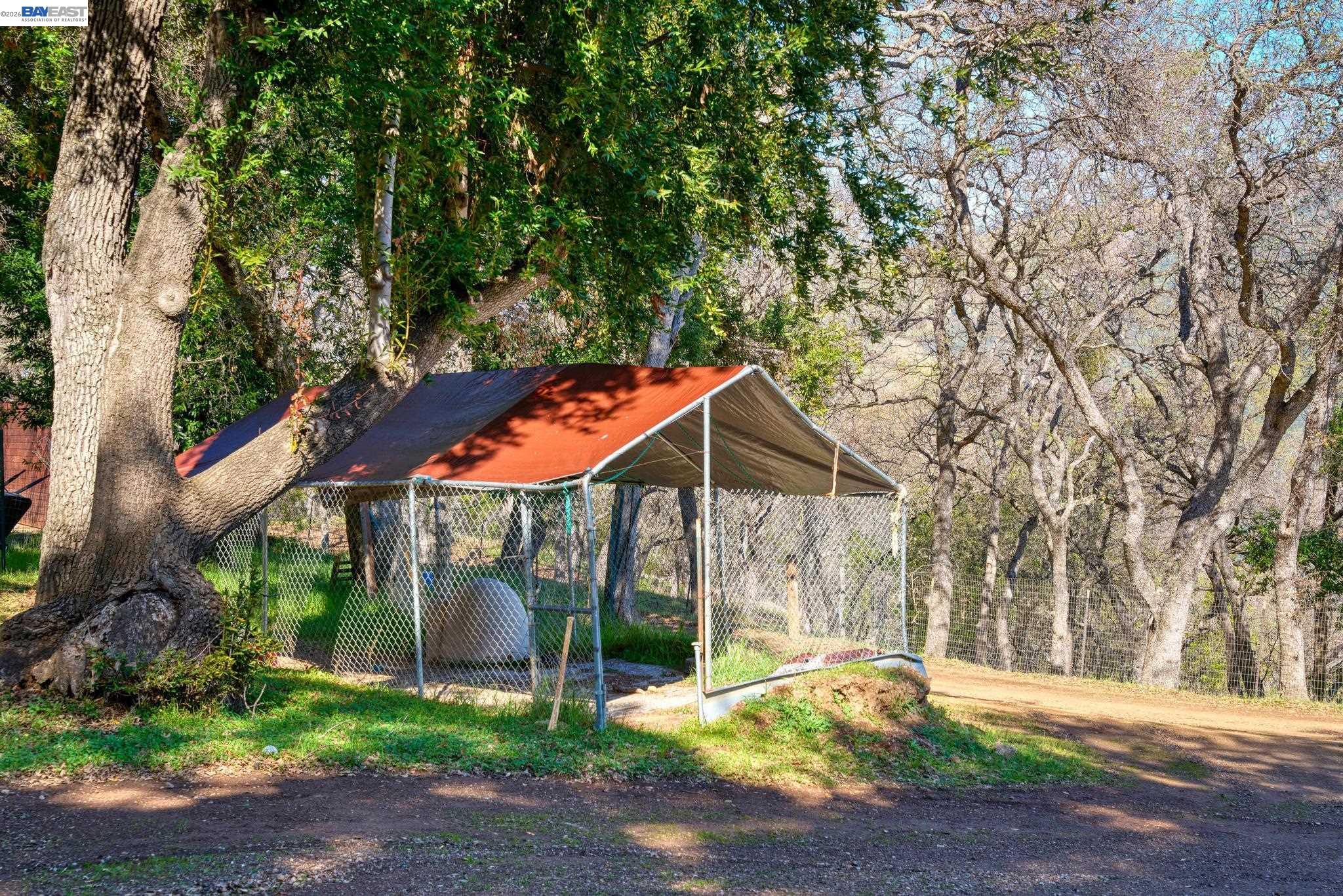7777 Del Valle Road Livermore, CA 94550 - Photo 51 of 60 a backyard of a house with table and chairs under an umbrella