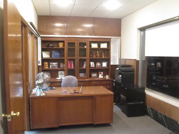 a room with stainless steel appliances wooden floor and view of kitchen