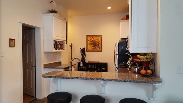 a kitchen with white cabinets and sink