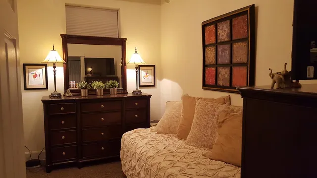 a bedroom with a bed and a flat tv screen on dresser