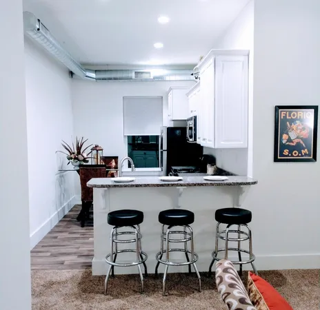 a kitchen with cabinets and chairs in it