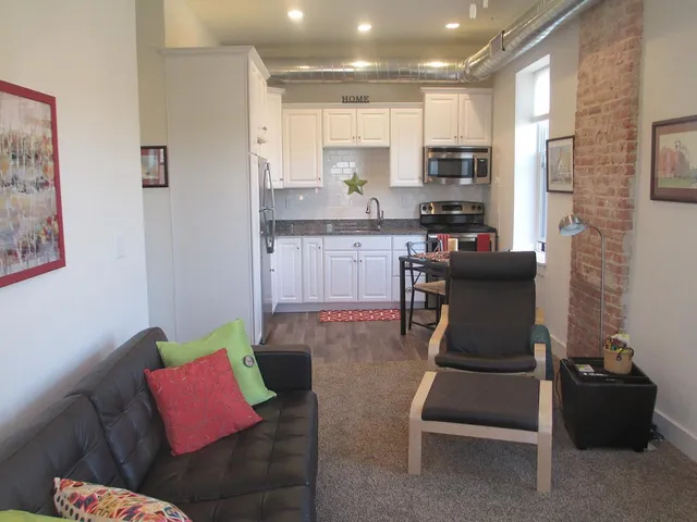 a living room with furniture and kitchen view