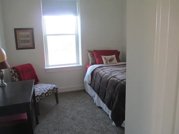 a bedroom with a bed and a window