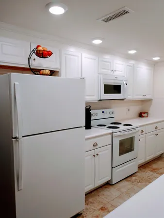 a kitchen with stainless steel appliances white cabinets and a refrigerator