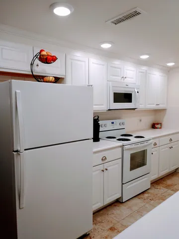 a kitchen with stainless steel appliances white cabinets and a refrigerator