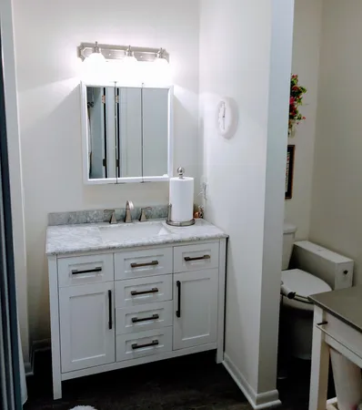 a bathroom with a granite countertop sink and a mirror