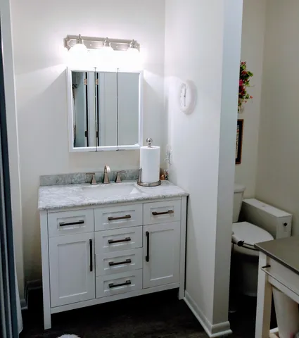 a bathroom with a granite countertop sink and a mirror