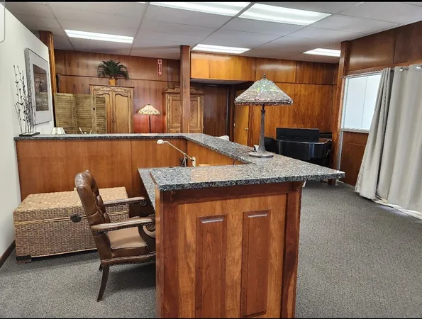 a living room with a table chairs and a refrigerator