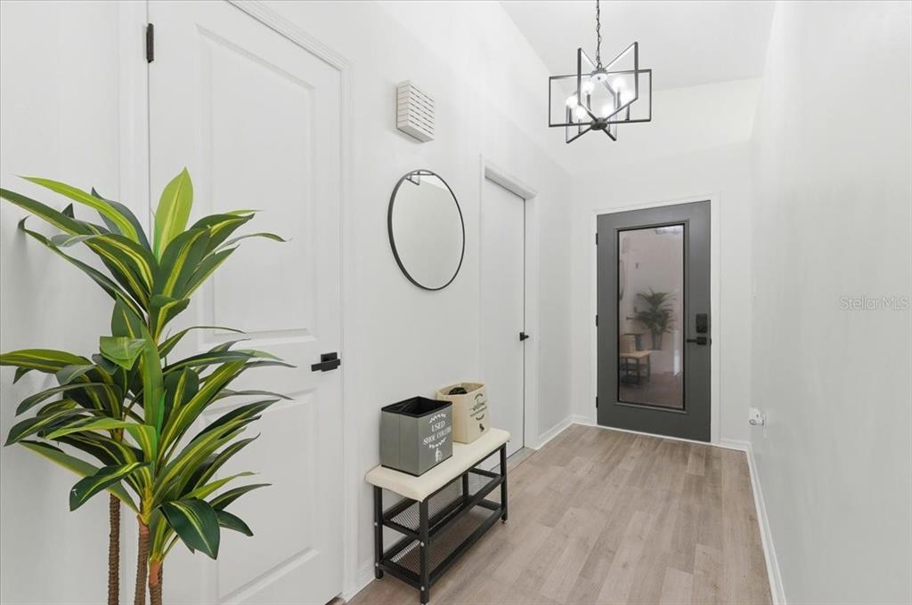 669 Eagle Run Lakeland, FL 33809 - Photo 4 of 69 a hallway with a potted plant on a table and a potted plant