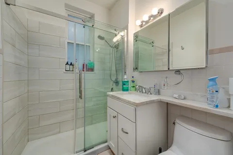 a bathroom with a sink a toilet and shower