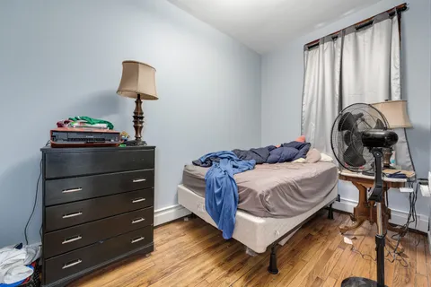 a bedroom with a bed and a lamp on dresser