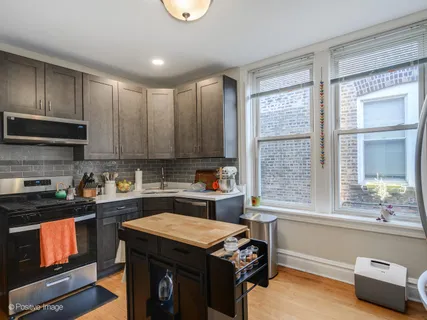 a kitchen with kitchen island a stove a sink and a microwave
