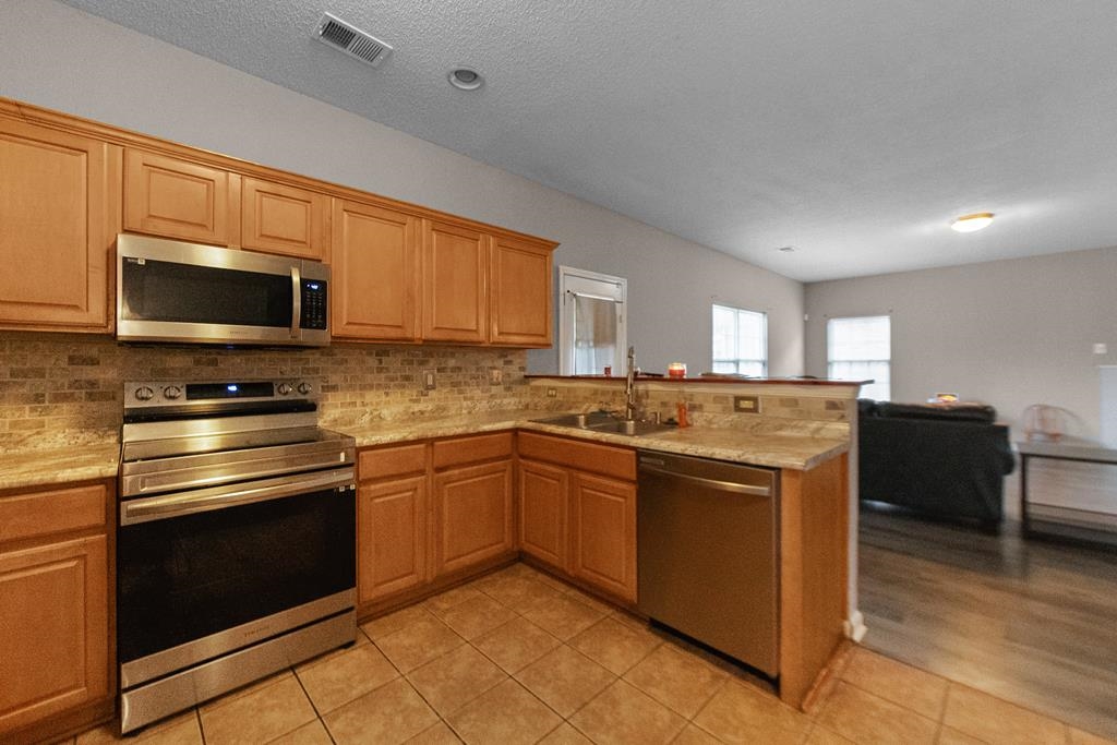 885 Ruby Creek Cove Memphis, TN 38109 - Photo 12 of 25 a kitchen with stainless steel appliances granite countertop a stove top oven a sink dishwasher a refrigerator and a microwave