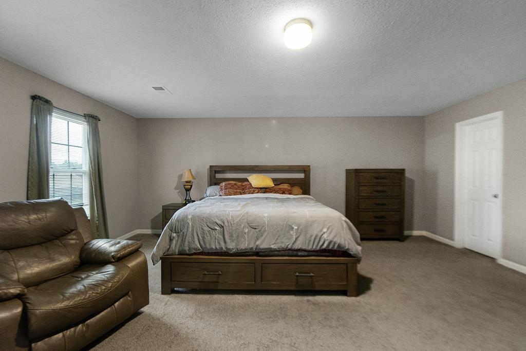 885 Ruby Creek Cove Memphis, TN 38109 - Photo 18 of 25 a spacious bedroom with a bed window and couch