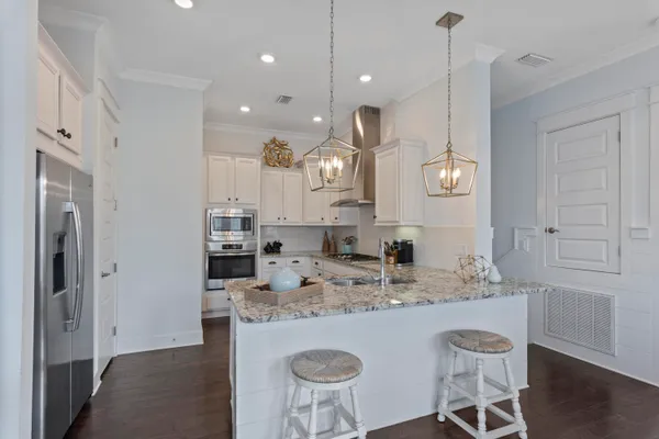 a kitchen with kitchen island granite countertop a sink a counter space and stainless steel appliances