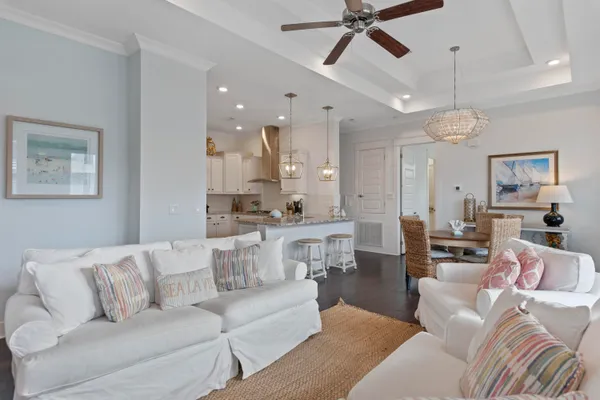 a living room with furniture kitchen view and a chandelier