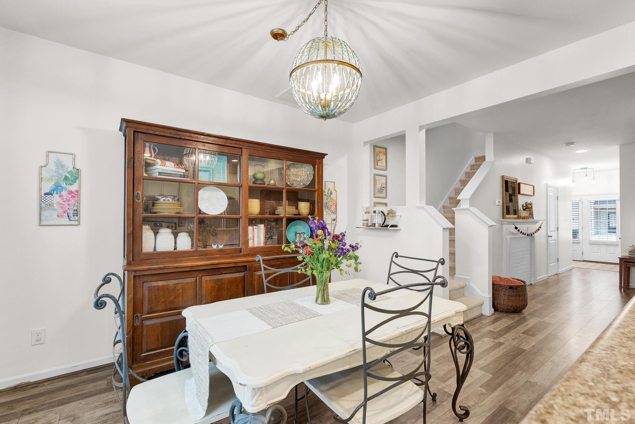 1004 Grand Ridge Drive Rolesville, NC 27571 - Photo 5 of 24 a view of a dining room with furniture a chandelier and wooden floor