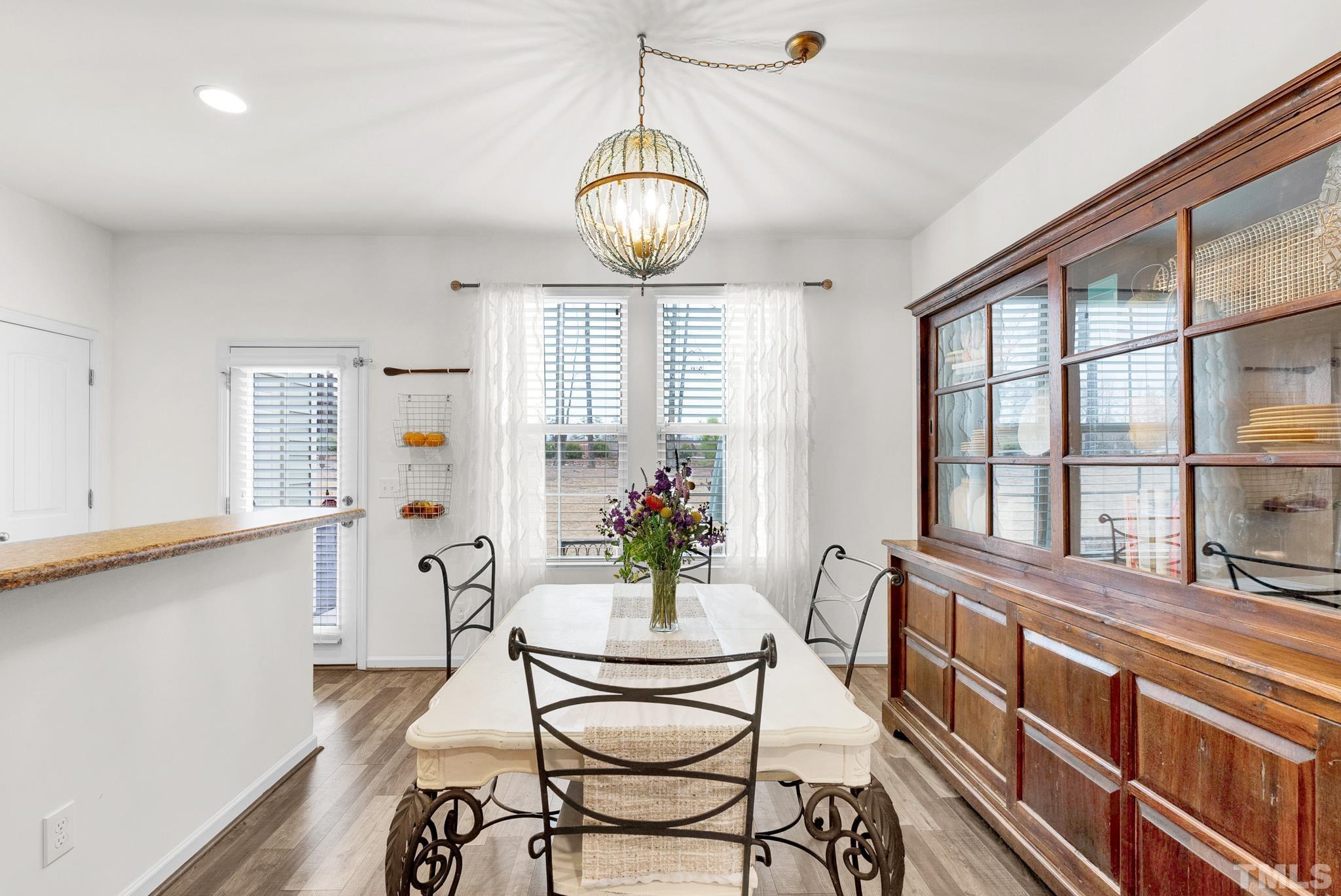 1004 Grand Ridge Drive Rolesville, NC 27571 - Photo 6 of 24 a dining room with wooden floor and large windows