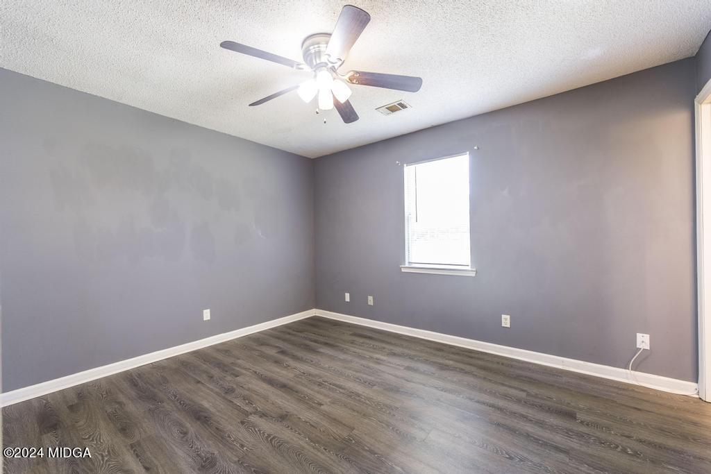 118 Toomer Road Perry, GA 31069 - Photo 19 of 30 an empty room with wooden floor and windows