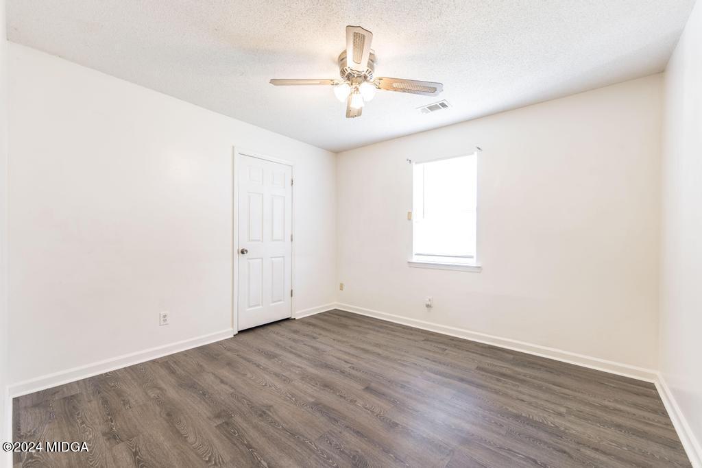 118 Toomer Road Perry, GA 31069 - Photo 25 of 30 an empty room with wooden floor and windows