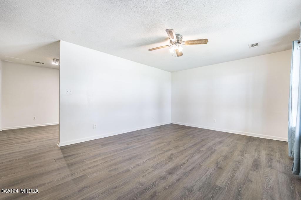 118 Toomer Road Perry, GA 31069 - Photo 9 of 30 an empty room with wooden floor ceiling fan and windows