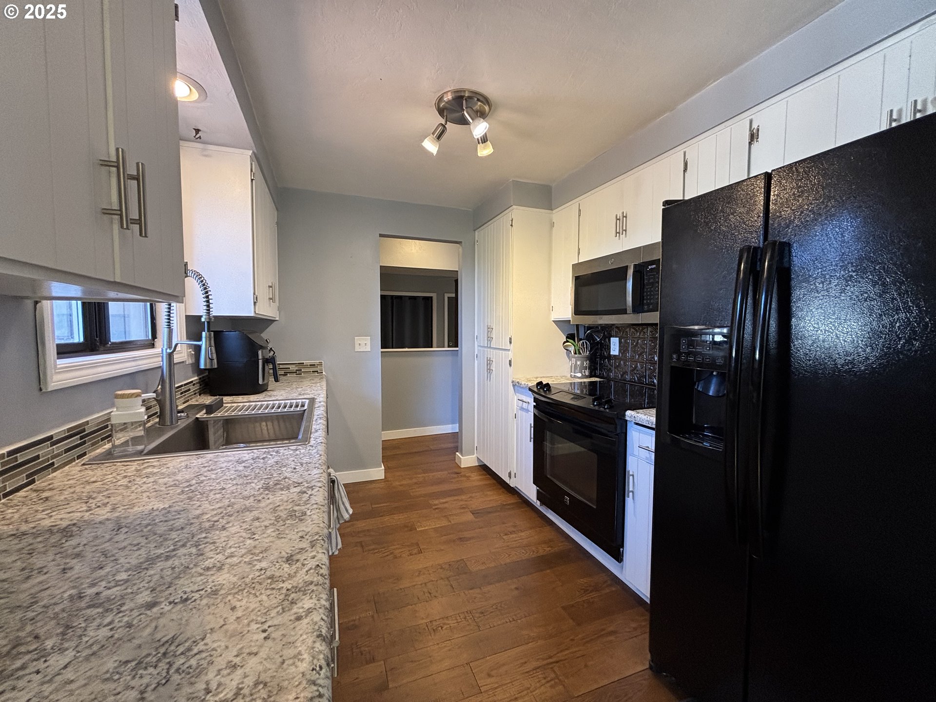 7066 Aster Street Springfield, OR 97478 - Photo 15 of 46 a large kitchen with stainless steel appliances kitchen island granite countertop a refrigerator and a stove top oven