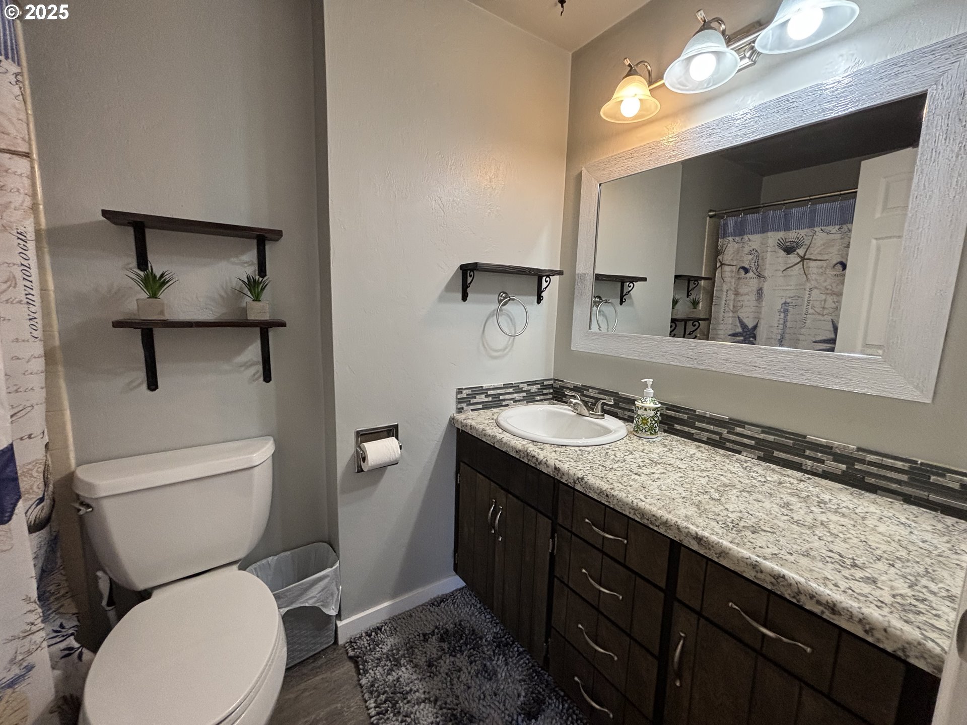 7066 Aster Street Springfield, OR 97478 - Photo 20 of 46 a bathroom with a granite countertop toilet sink and mirror