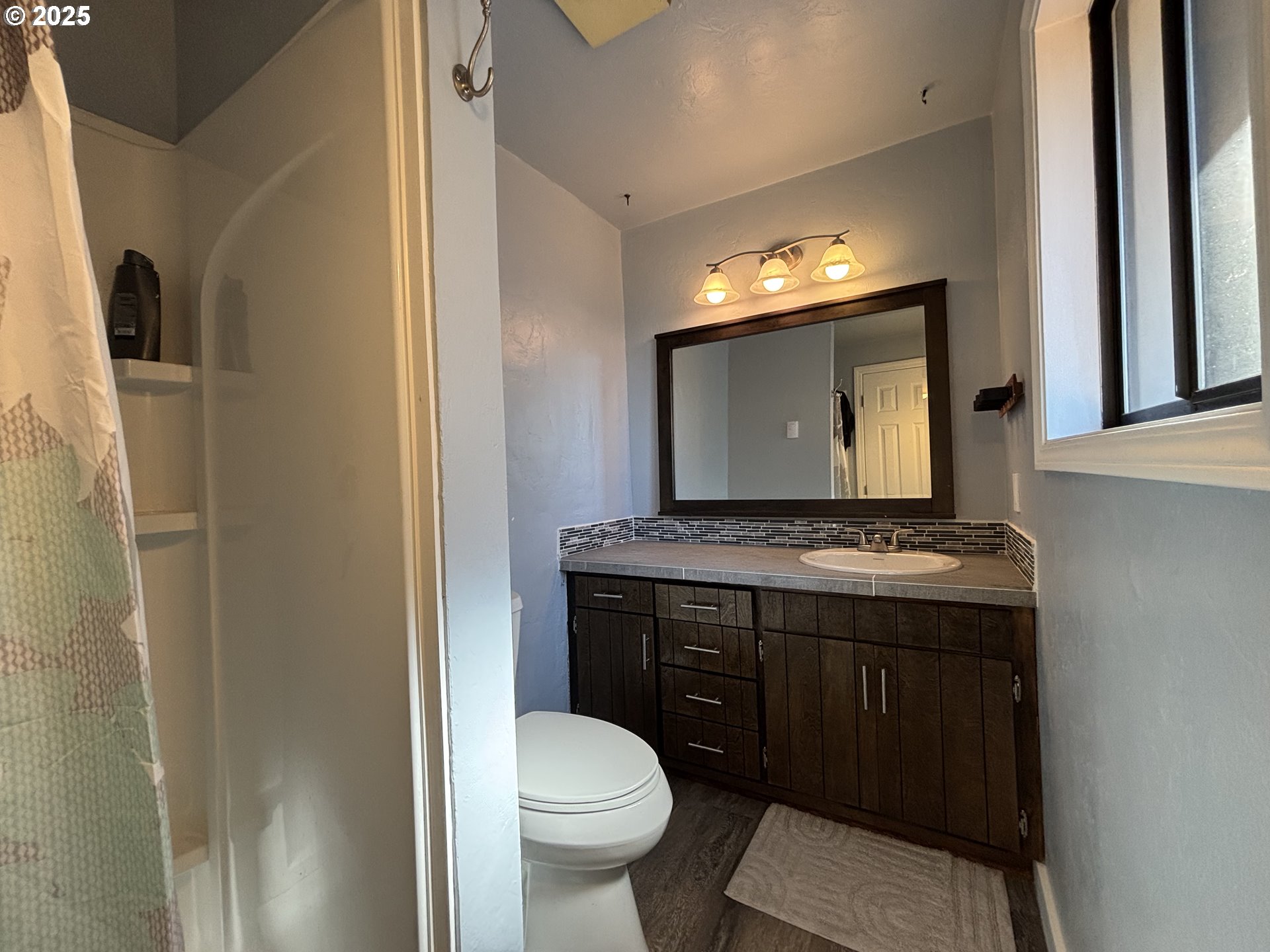 7066 Aster Street Springfield, OR 97478 - Photo 28 of 46 a bathroom with a granite countertop toilet sink and mirror
