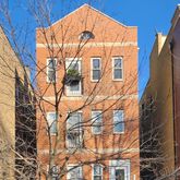 a open kitchen with stainless steel appliances granite countertop a stove a refrigerator a sink a dining table and chairs with wooden floor