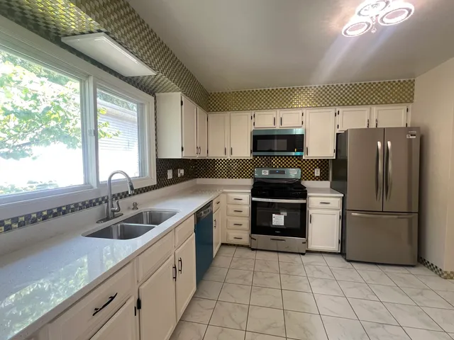 a kitchen with a sink cabinets and stainless steel appliances