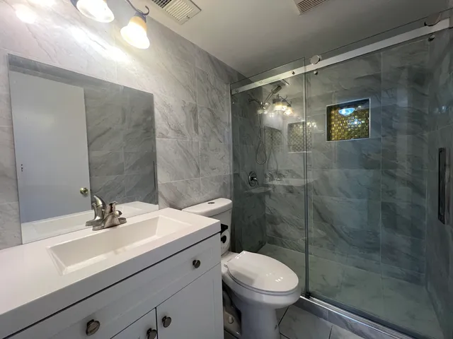 a bathroom with a sink a toilet and shower